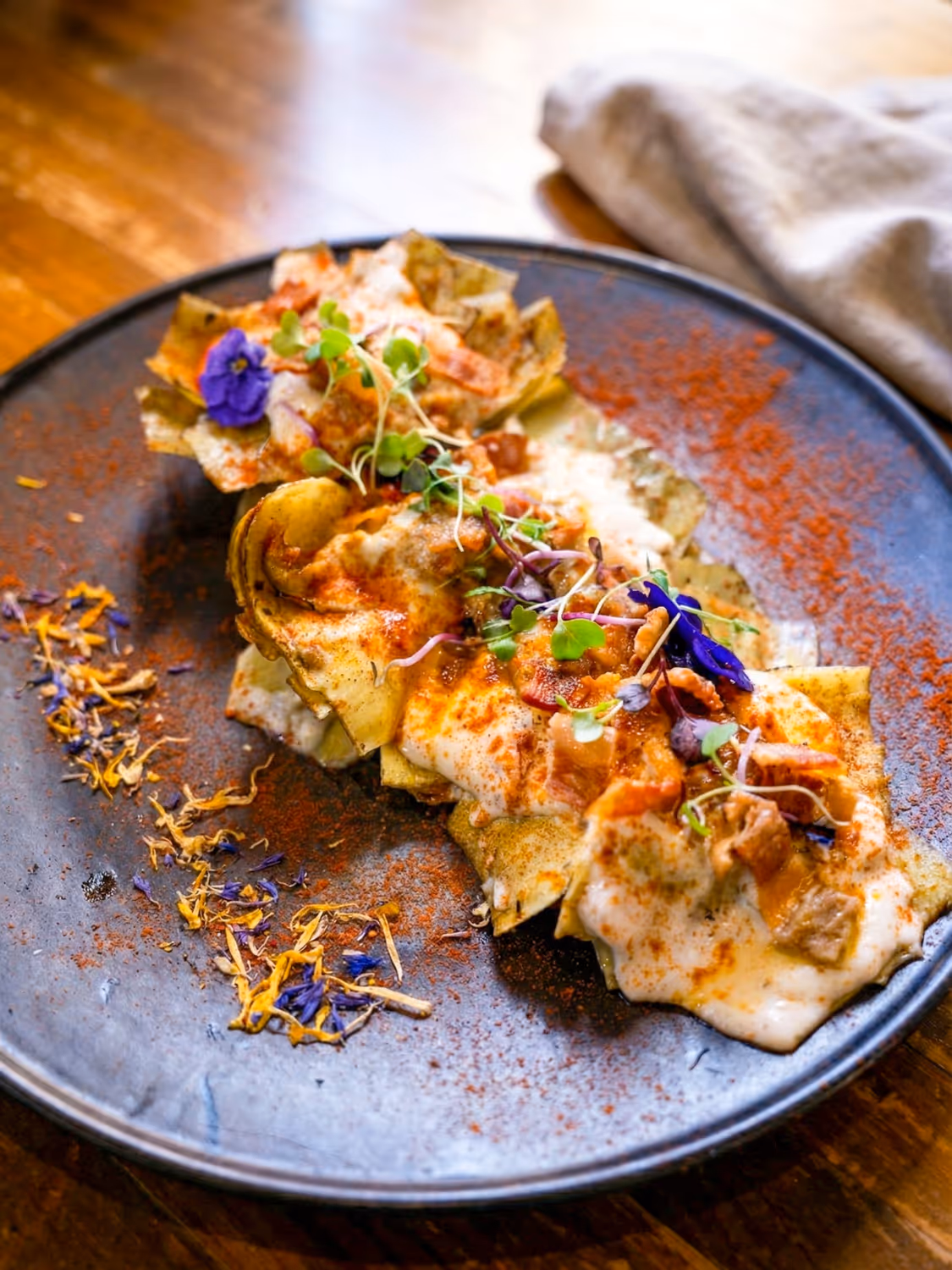 Alcachofas tiernas bañadas en una cremosa bechamel ahumada con panceta de cerdo crujiente y un delicado toque de foie
