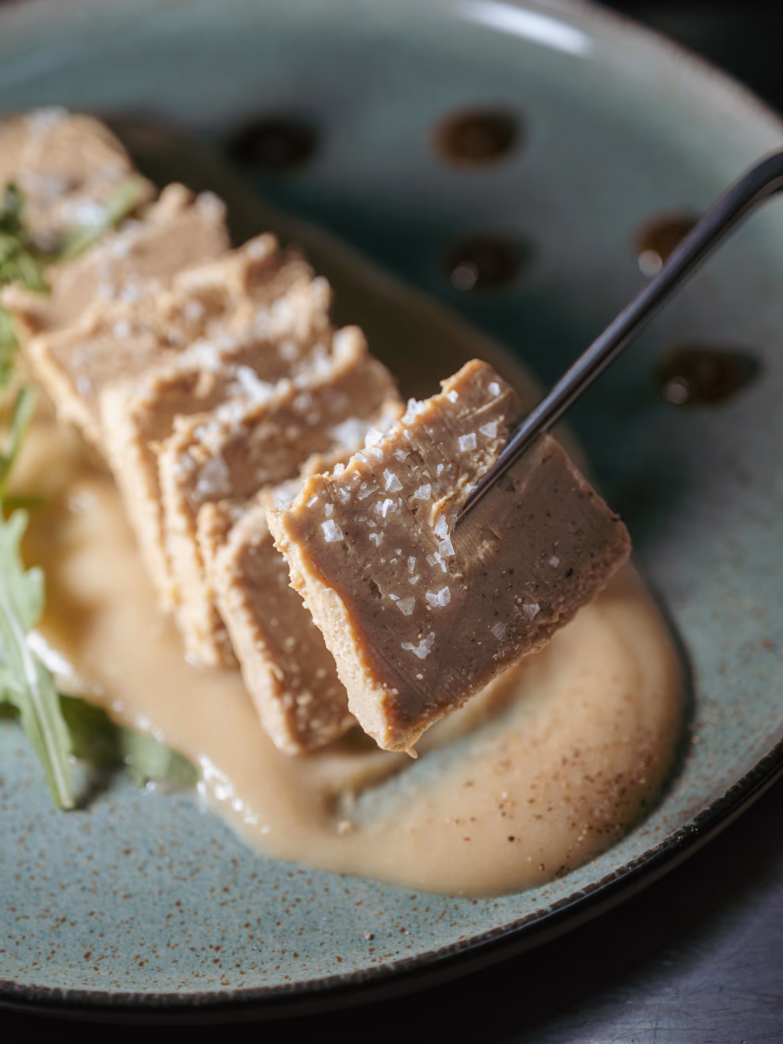 Foie micuit sobre una ligera compota de pera, rúcula fresca y pan crujiente, terminado con una sutil reducción de Pedro Ximénez